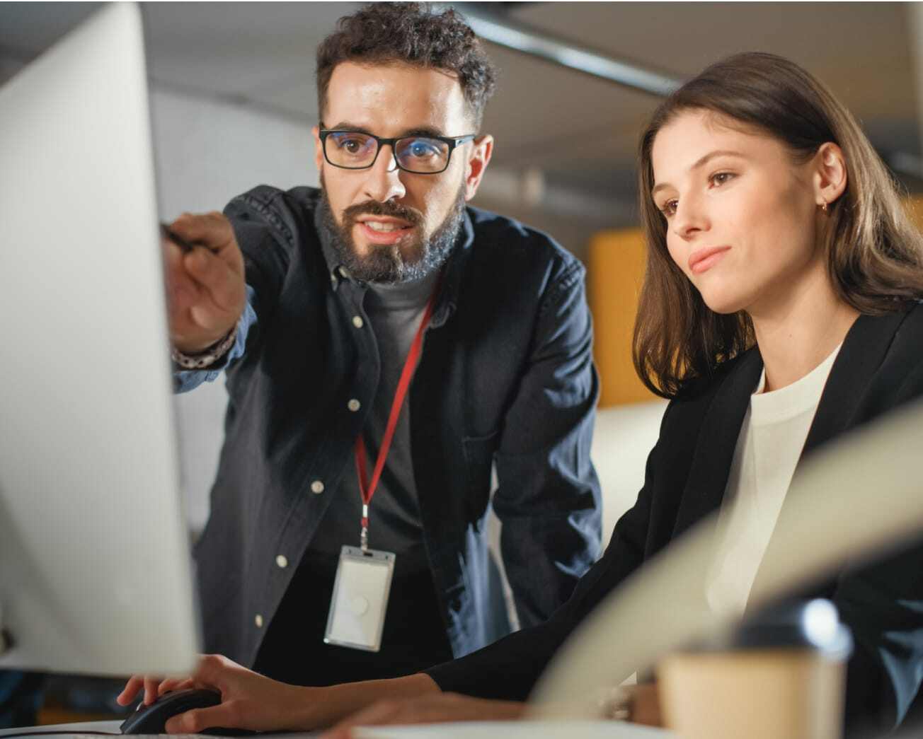 man pointing at colleague's computer screen