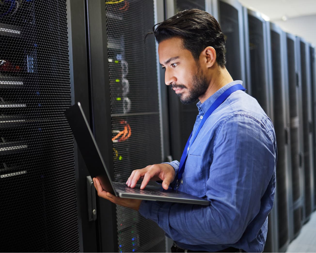 man using laptop in server room